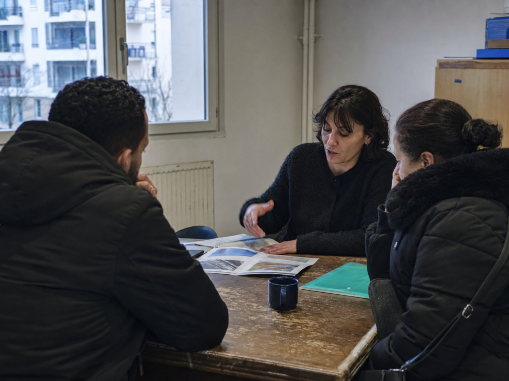 Une représentante échange avec des habitants autour de leurs questions de logement.